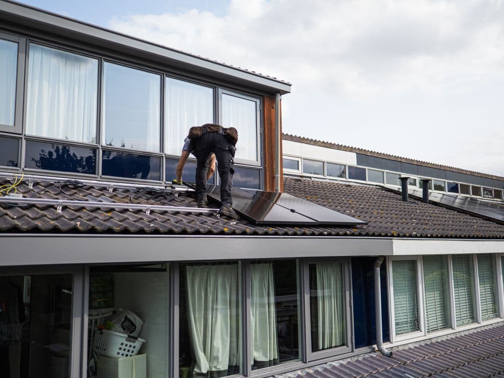 Installateur MGM Transition posant des panneaux solaires sur une toiture